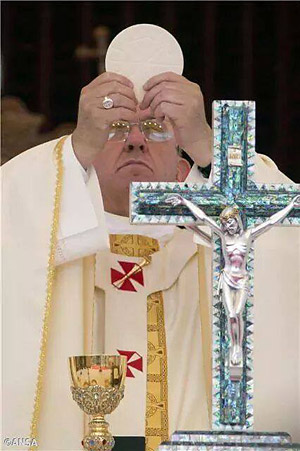 With the crucifix in the background, the priests of the harlot church of Rome carry out the blasphemous Eucharist ceremony.